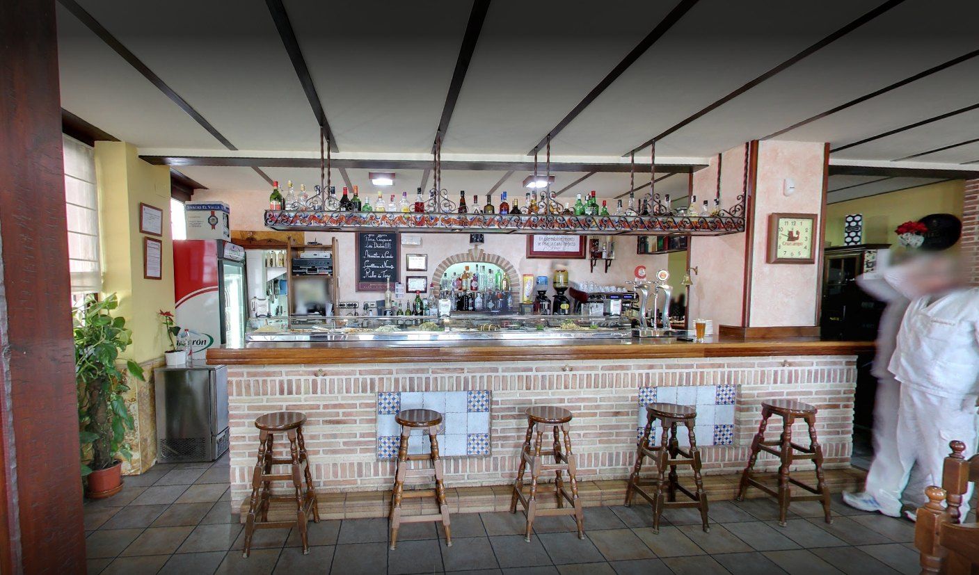 Barra del bar El Suquet con taburetes, botellero y vitrina de tapas