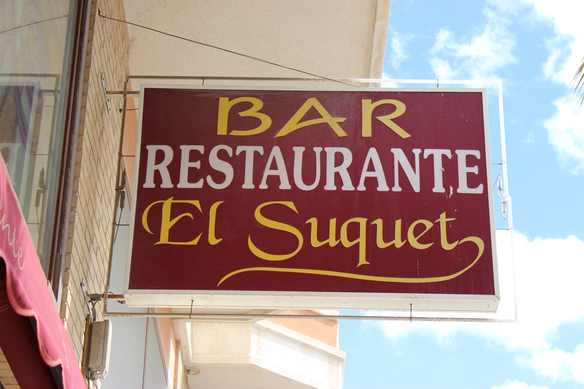 Rótulo rojo de «Bar Restaurante El Suquet» en la fachada, en Torrellano
