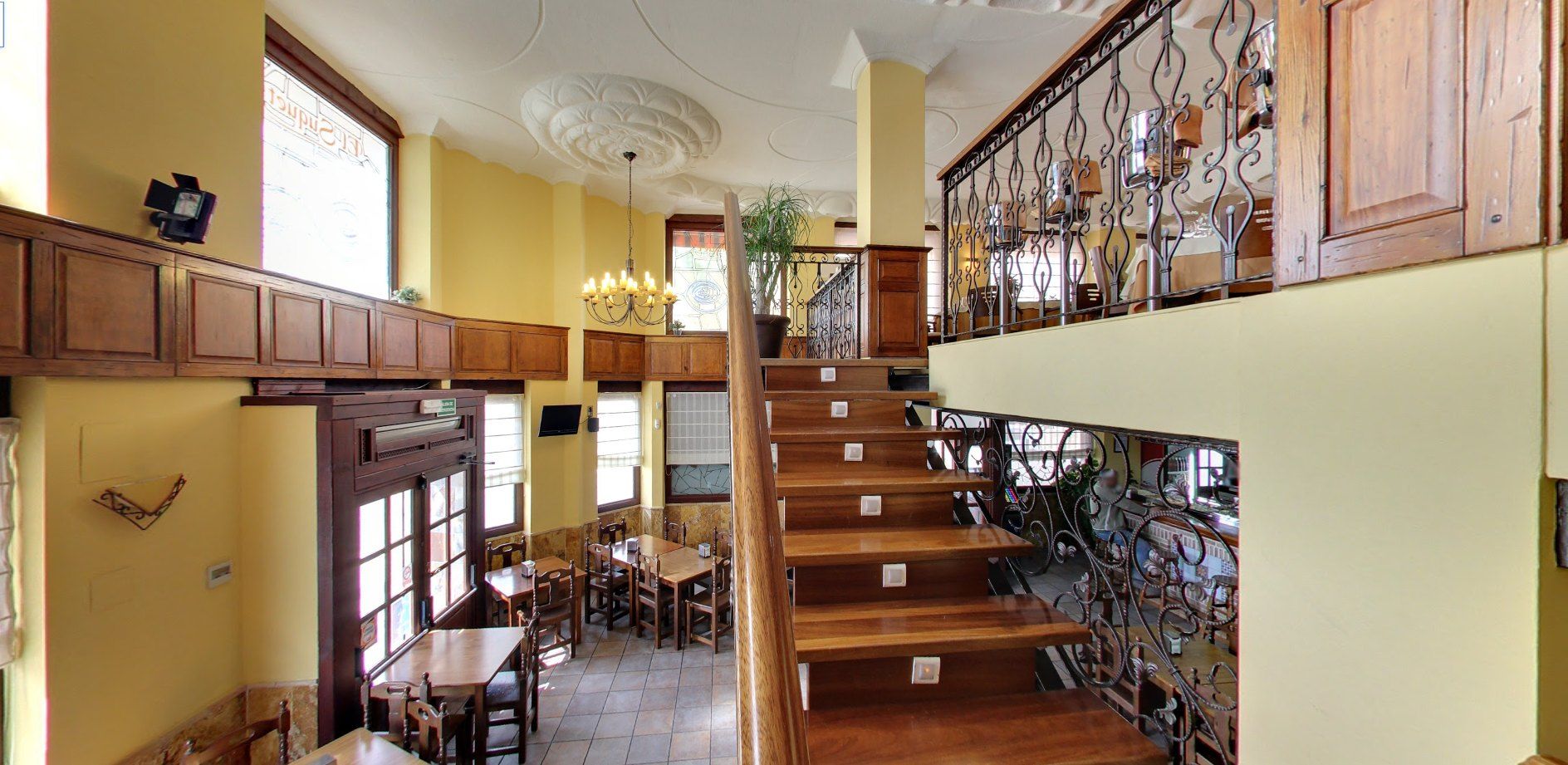 Vista del comedor con la escalera y la balconada de madera del salón