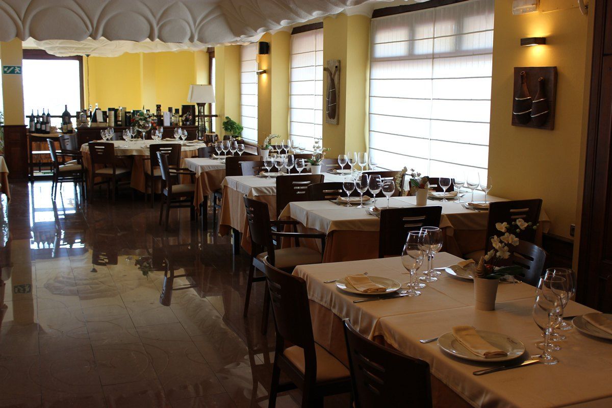 Mesas con mantel y copas en el salón de la primera planta